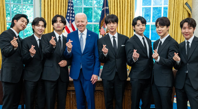 5월 31일 미국 백악관 대통령 집무실에서 조 바이든 미국 대통령(왼쪽에서 네 번째)과 BTS 멤버들이 손가락으로 하트를 만들며 포즈를 취하고 있다. [BTS 트위터]